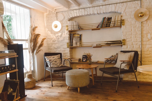 white painted brick wall with two chairs and round coffee table